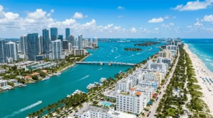 Aerial view of Miami's Brickell skyline, Biscayne Bay, and Miami Beach coastline on a sunny day