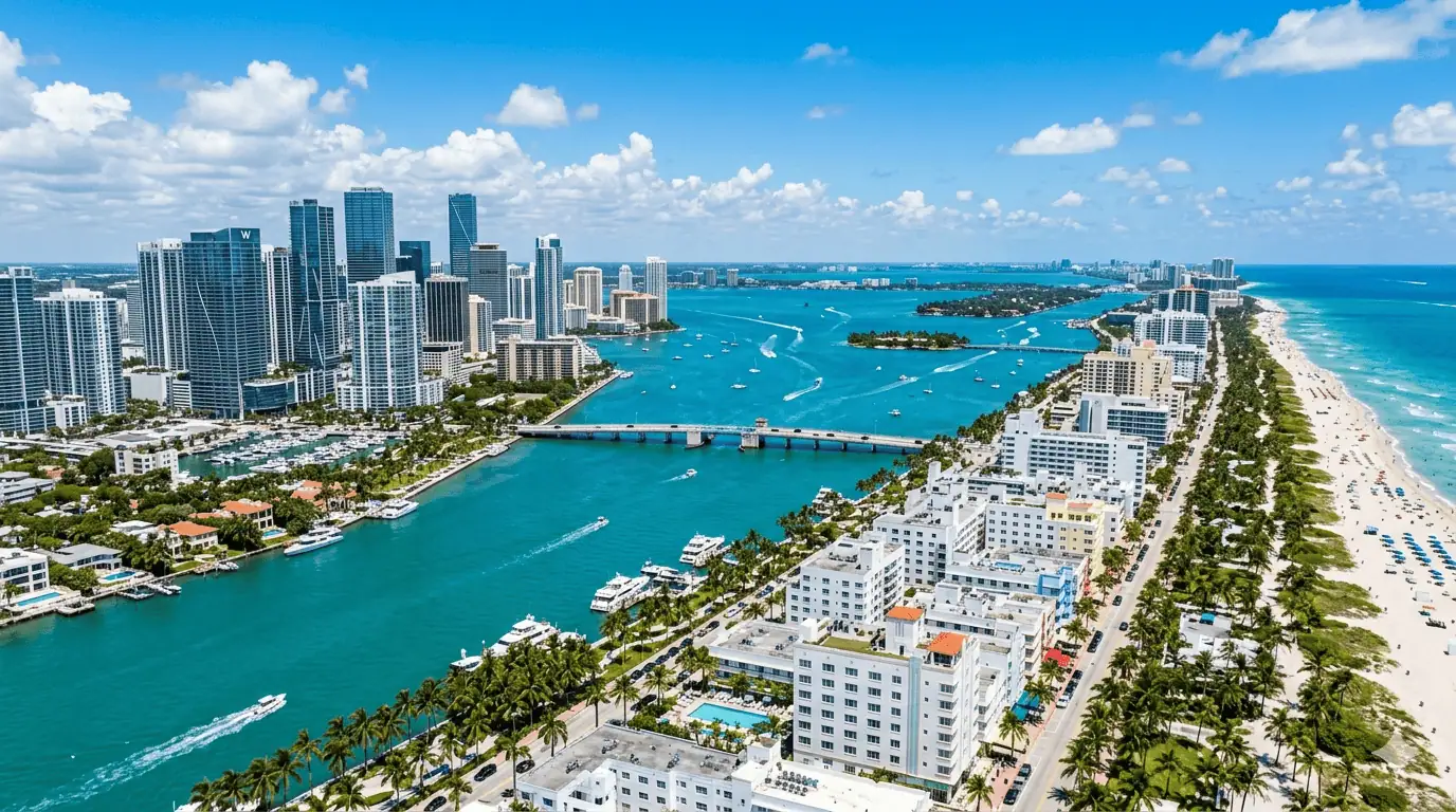 Aerial view of Miami's Brickell skyline, Biscayne Bay, and Miami Beach coastline on a sunny day